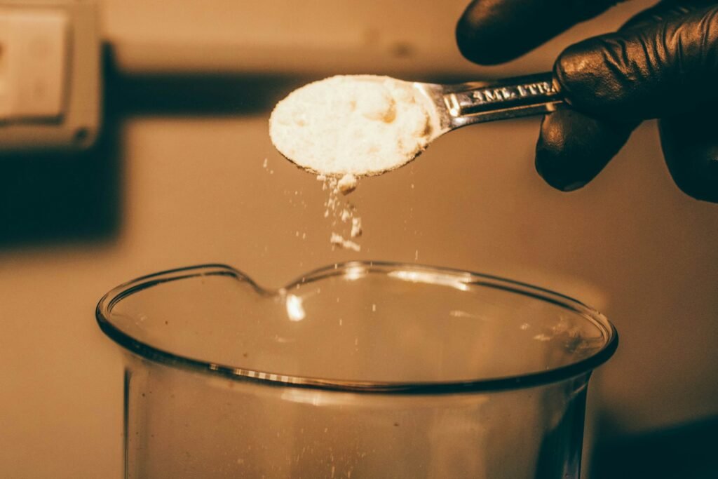 un cucharada de bicarbonato blanco cayendo sobre un envase