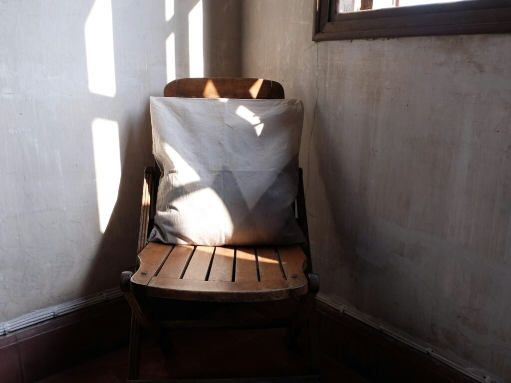 una silla de madera dentro de una habitación pequeña