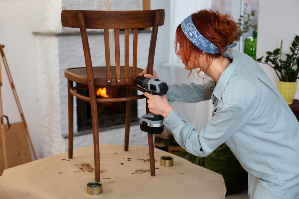 una mujer dandole los toque finales a una silla a la que le estaba aplicando el efecto de envejecimiento a uno de sus muebles